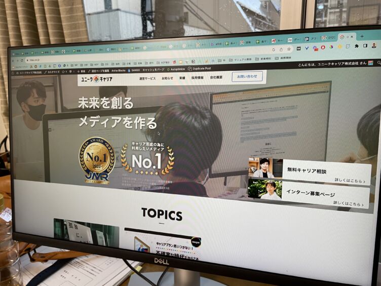 パソコンの画面に映るユニークキャリア株式会社のサイト