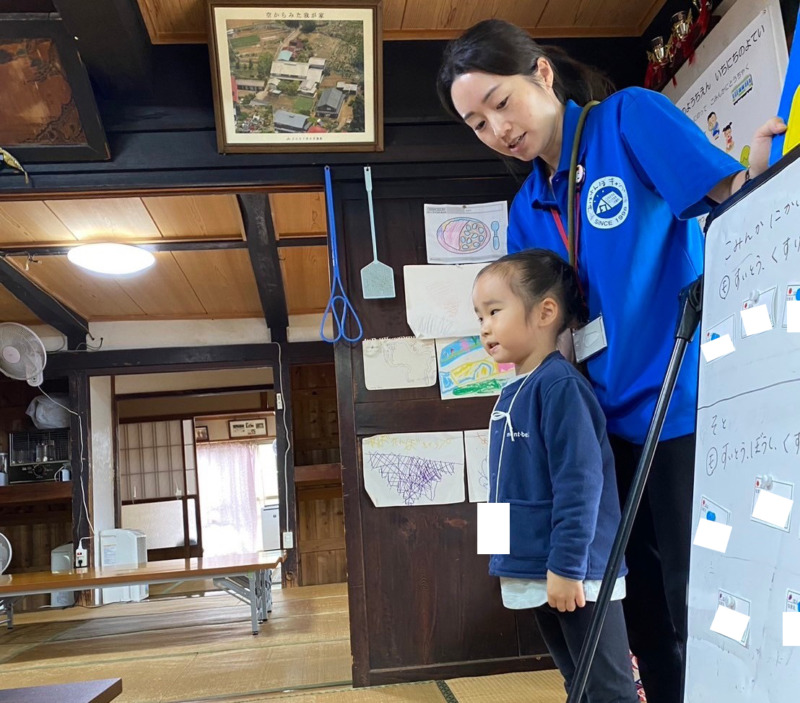 NPO法人野外遊び喜び総合研究所の稲木さんと子どもの挨拶のようす