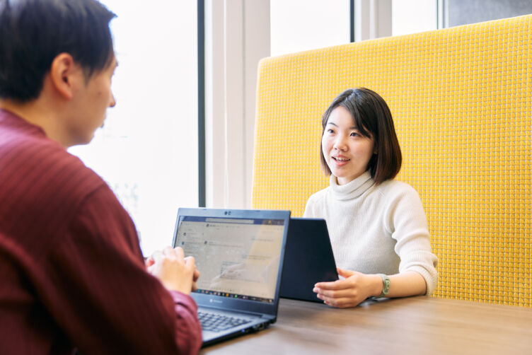 アイムファクトリー株式会社の社内で打ち合わせをする男性社員と女性社員