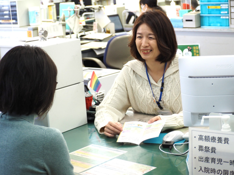 竹内さんの仕事風景。窓口で国民健康保険の制度を案内する様子。