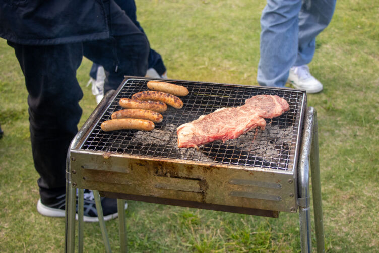 グリルで焼かれる肉とソーセージ