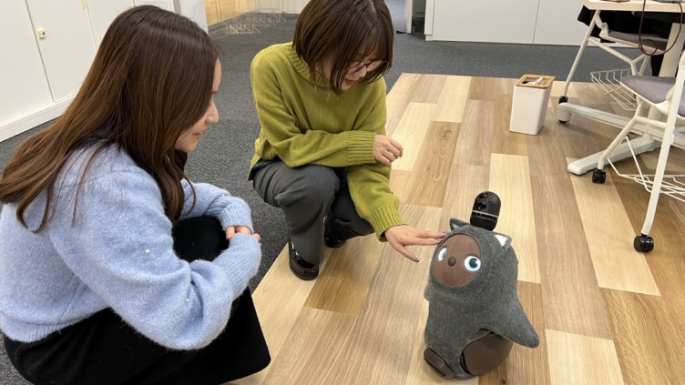 オフィスのロボットをかわいがる株式会社CHINTAIの豊島さんと齋藤さん