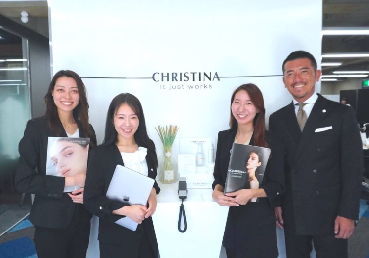 株式会社CHRISTINA JAPANのオフィスエントランスに立つメンバー