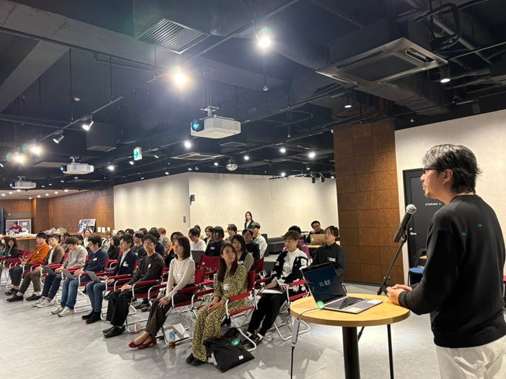 オフライン全体会議でドコドア株式会社の代表が発表する様子