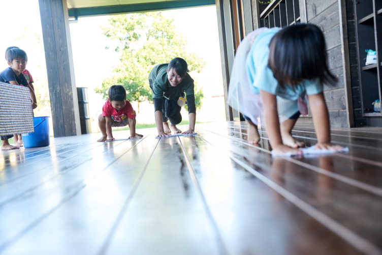 社会福祉法人どろんこ会の運営施設で雑巾がけをする子どもとスタッフ