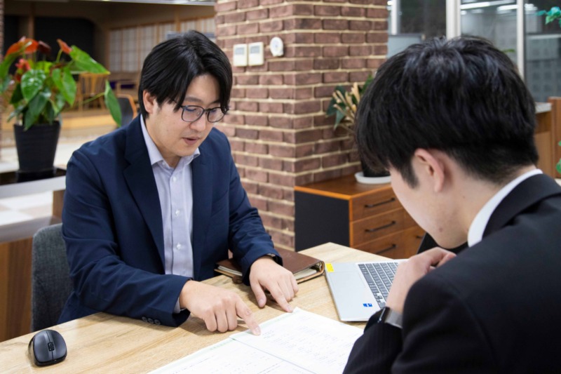 ハタス株式会社の山本さんが若手社員に指導をしている様子