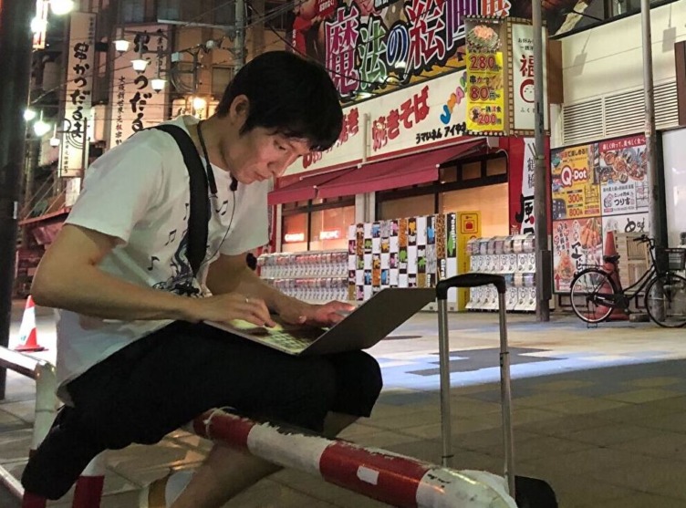 株式会社SAGOJOのメンバーが大阪の街中でPCを開いている風景