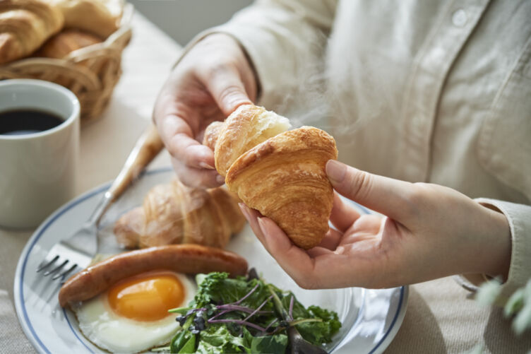 株式会社スタイルブレッドのクロワッサンを手に食事をしている様子