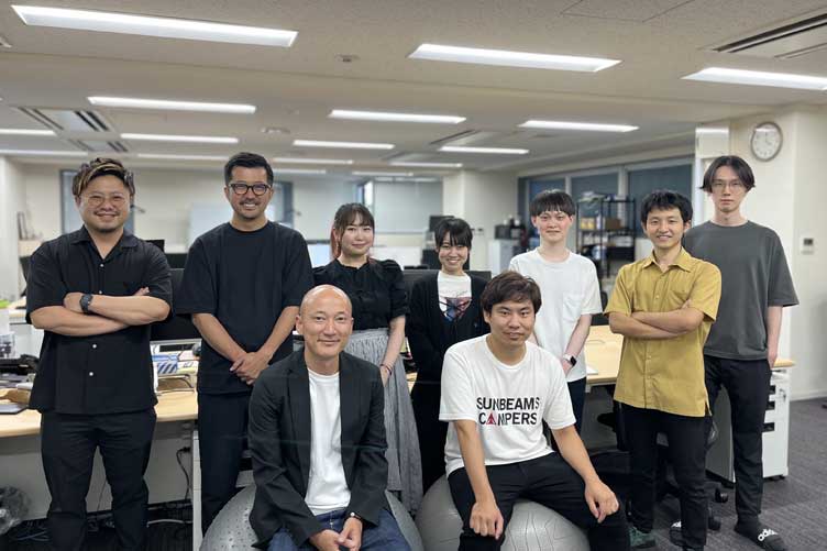 株式会社TAG STUDIOの社内で集合する代表取締役・石橋知幸様、サブマネージャー・S様と一部の社員の方々