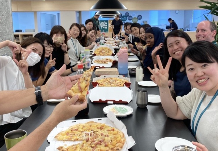 田中学園立命館慶祥小学校の教職員がピザを食べて交流している様子