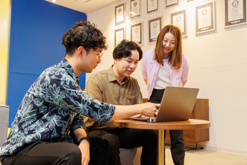 合同会社ユー・エス・ジェイの宮崎さん・デレクさん・加藤さんがPCで作業している様子